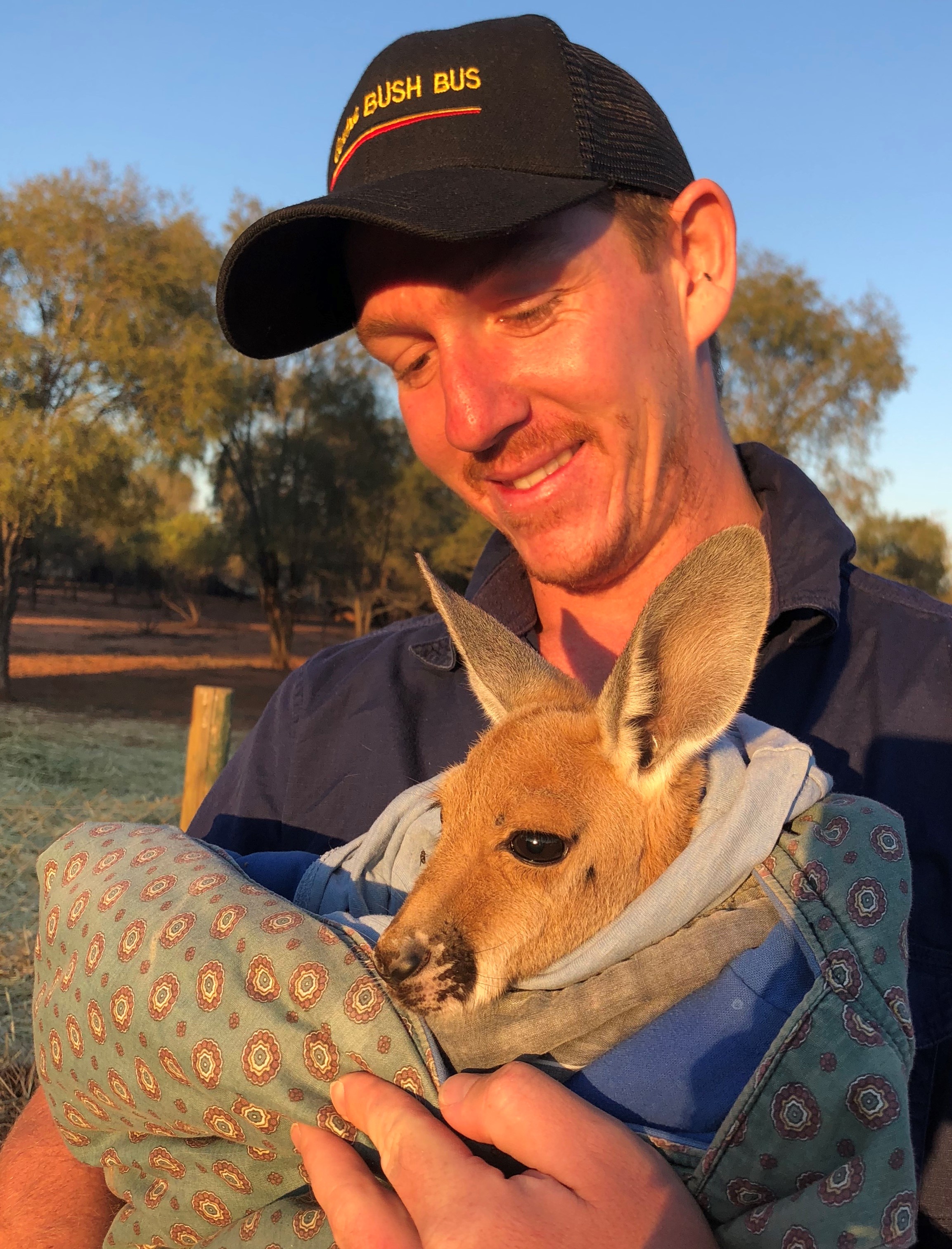 Stringer cuddling baby kangaroo on tour